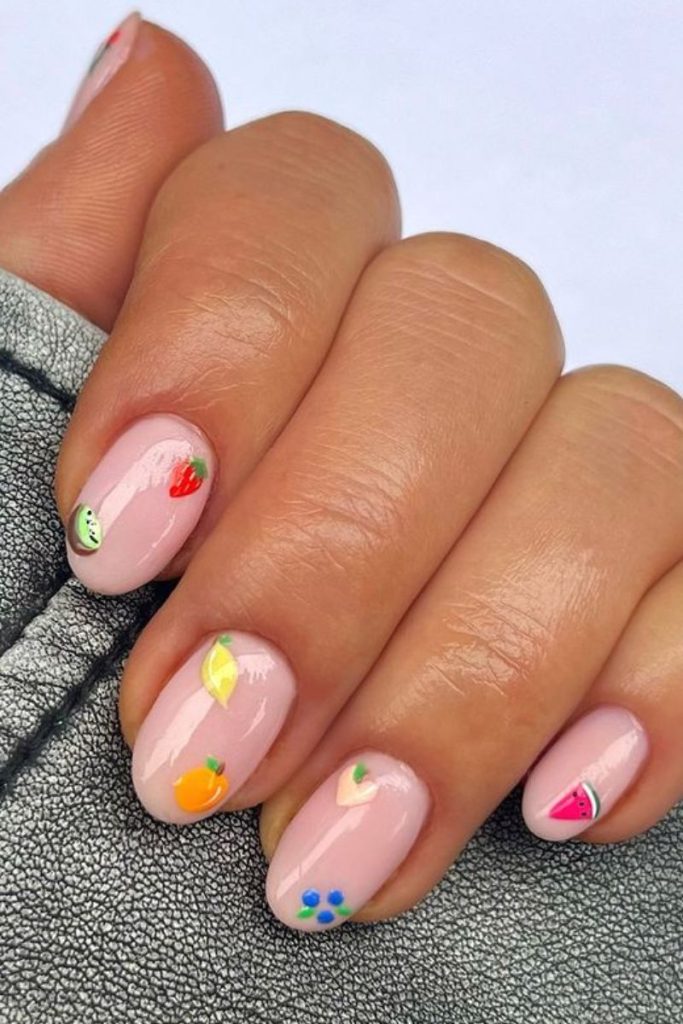 Idées d'ongles de vacances : base nue avec des motifs de fruits