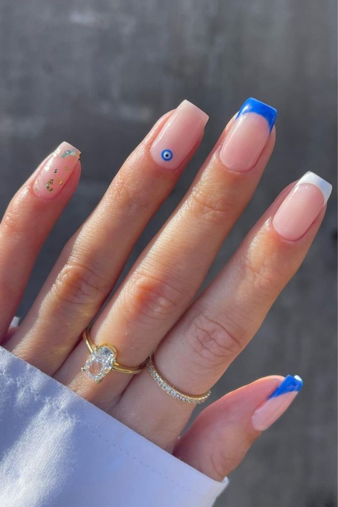 Idées d'ongles pour les vacances : pointes bleues et blanches avec motif mauvais œil